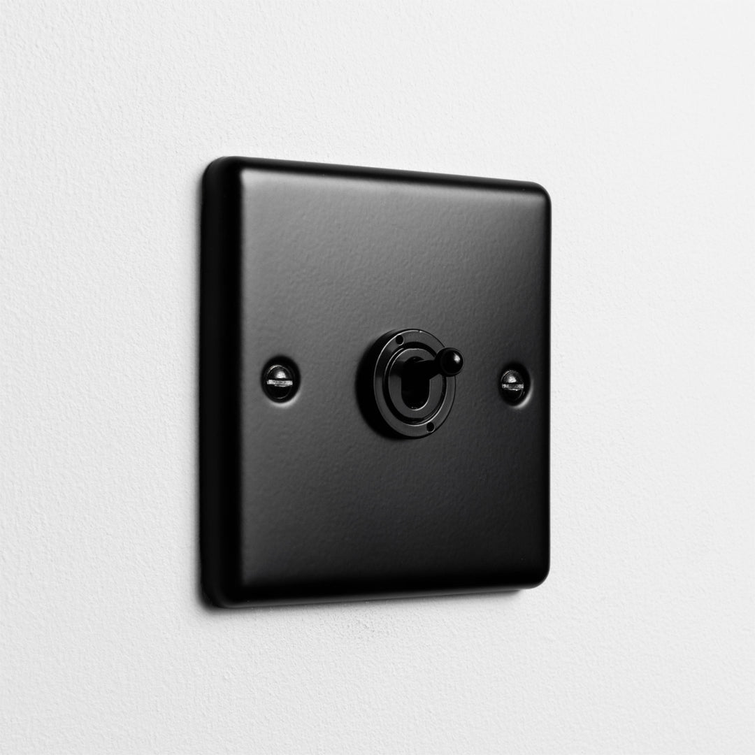 Matt Black 1 Gang 2 Way Toggle Switch On Light Grey Background