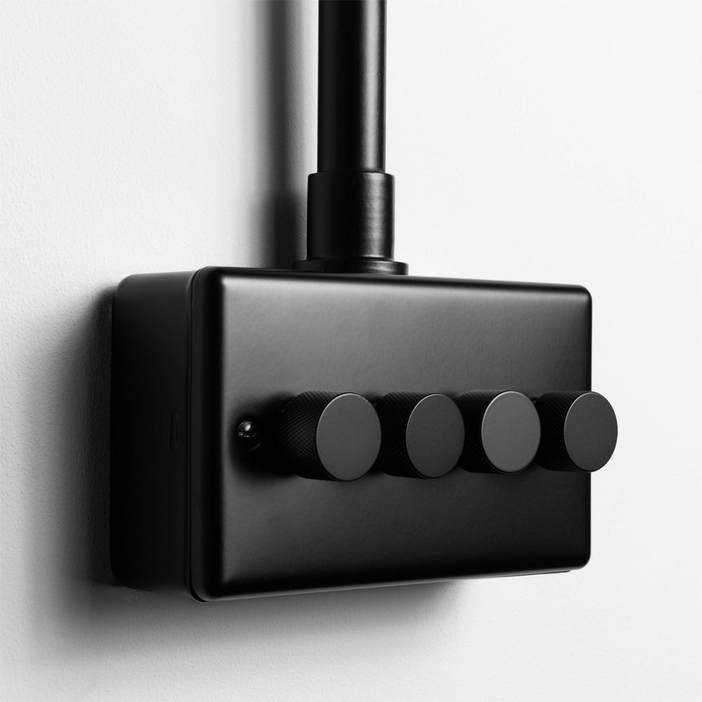 Matt Black 4 Gang LED Dimmer Switch With Back Box And Conduit On A Light Grey Background 