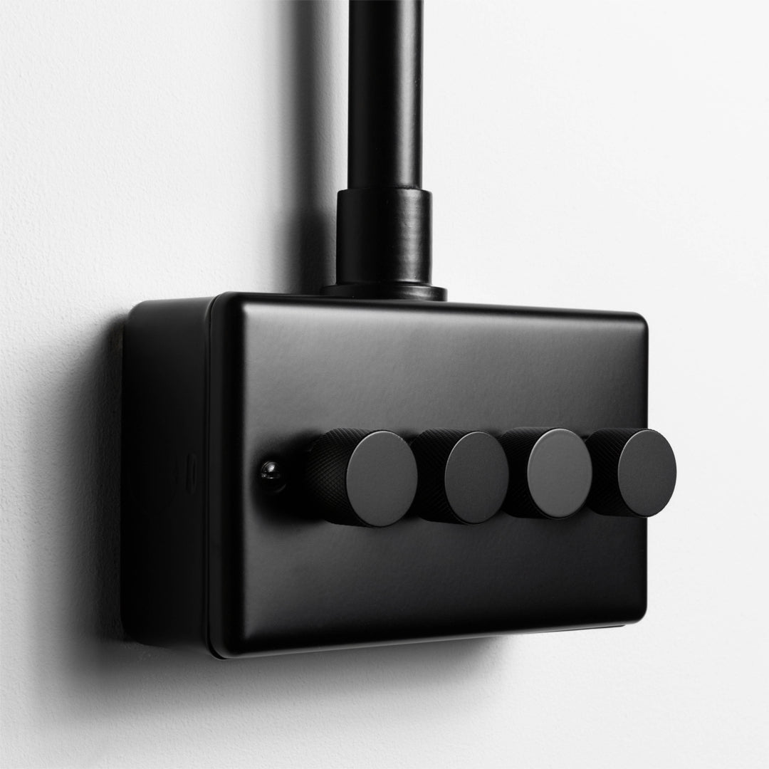Matt Black 4 Gang LED Dimmer Switch With Back Box And Conduit On A Light Grey Background 