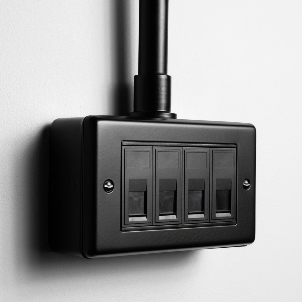 Matt Black 4 Gang RJ45 Socket With Back Box And Conduit On A Light Grey Background