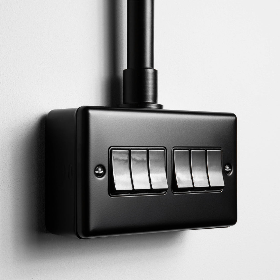 Matt Black 6 Gang 2 Way Switch With Black Insert With Back Box And Conduit On Light Grey Background