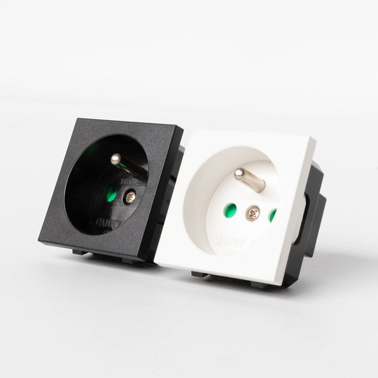 A black and white French socket module with a round earth grounding pin and a switch lever.