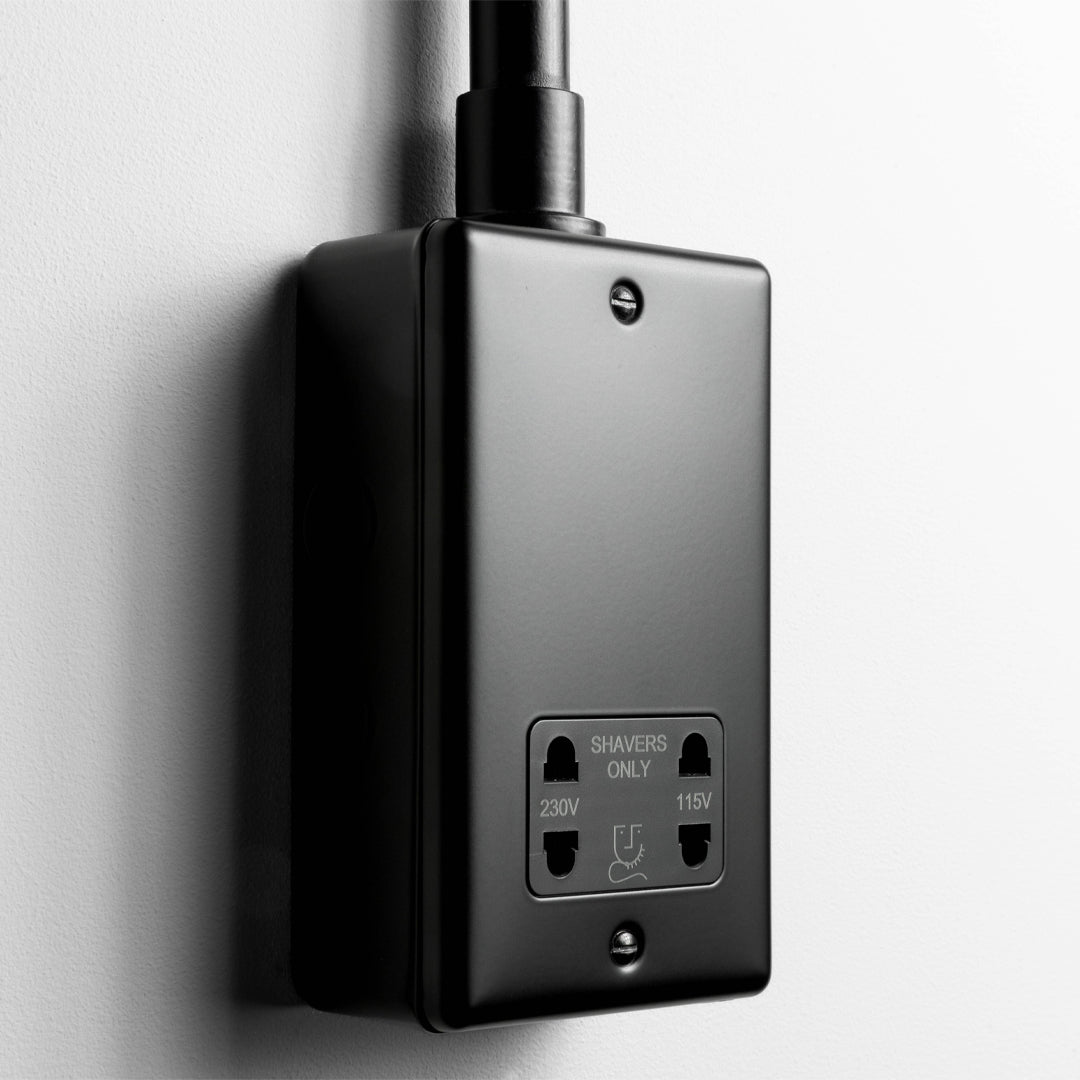 Matt Black Dual Voltage Shaver Socket With Back Box And Conduit On A Light Grey Background