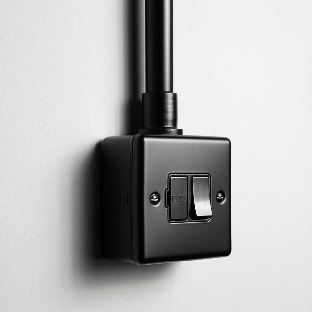 Matt Black Switched Fused Connection Switch With Back Box And Conduit On A Light Grey Background
