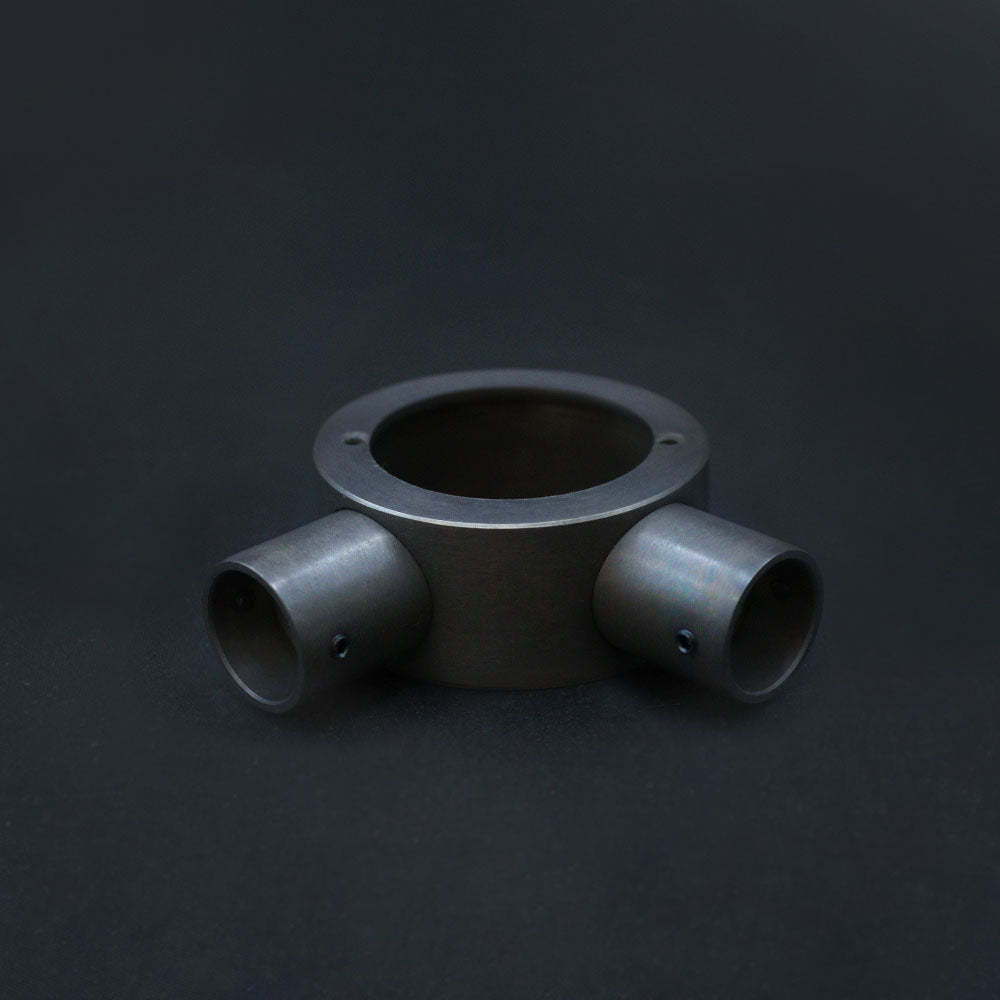 A dark bronze angle box with conduit, machined from solid brass on a ark background